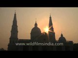 Basilica of Our Lady Of Graces, silhouetted against a sunrise sky - in Sardhana