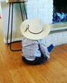 Toddler in Cowboy Hat Rides Robotic Vacuum Cleaner