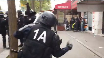 Un CRS jette un pavé sur les manifestants