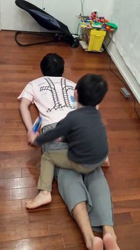Il se fait masser le dos par son fils qui fait rouler son train sur son tshirt