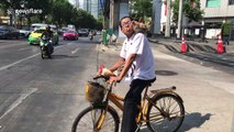 Cyclist takes chicken for a ride during morning rush hour in Thailand