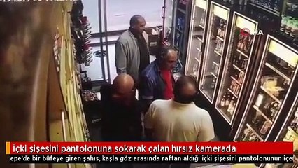 İçki şişesini pantolonuna sokarak çalan hırsız kamerada