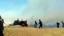 شاب يقفز من جراره الزراعي بعد احتراقه خلال إطفاء حرائق المحاصيل بالرقة (فيديو)