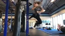 Female Martial Artist Does Spinning Kick on Punching Bag