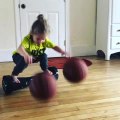 Little Girl Dribbles Two Basketballs While Balancing on Hoverboard