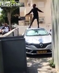 Man jumping on the car roof goes through the windshield