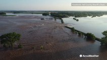 Drone captures water pouring over breached levee