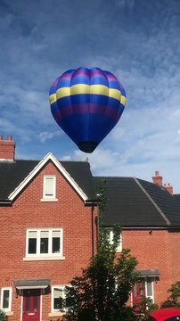 Balade en montgolfière au-dessus de maisons dans un quartier résidentiel !