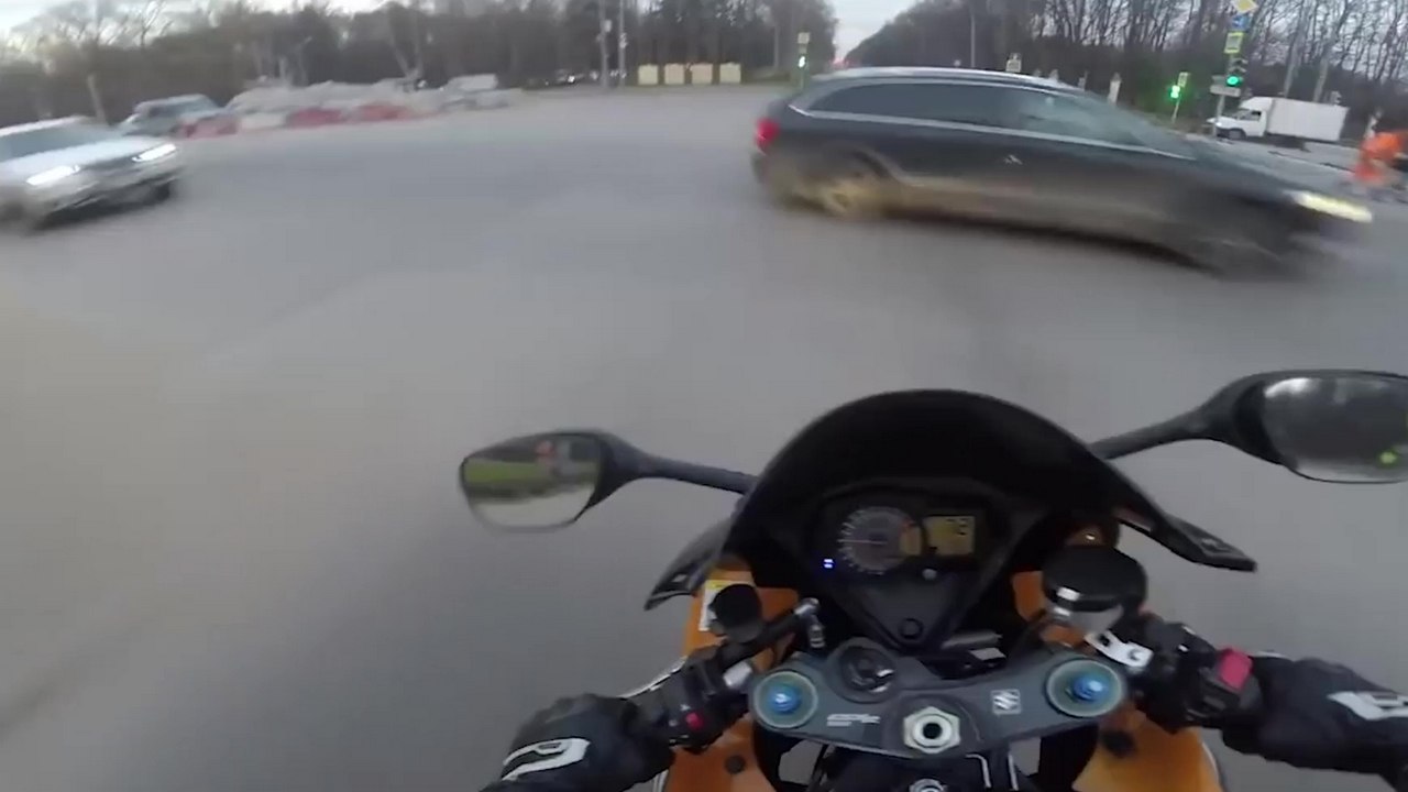 Un motard frôle de près la mort en grillant un feu rouge juste après un wheeling