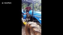 Honduran driver leaps to safety as tractor falls into raging river