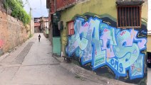 Vassoura em mãos e grafite nas paredes