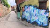 Vassoura em mãos e grafite nas paredes