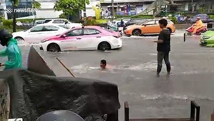 Man goes surfing on flooded Thai road after heavy rain