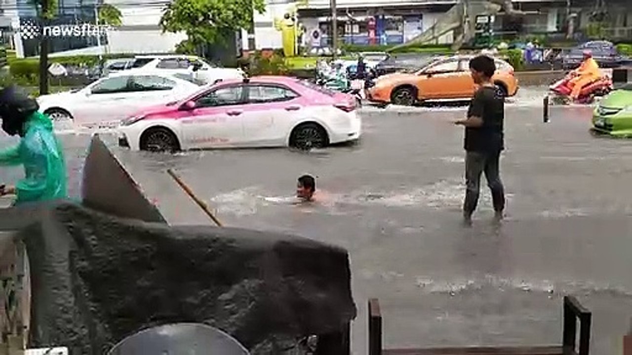 Man goes surfing on flooded Thai road after heavy rain