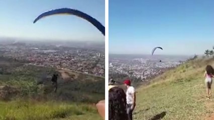 Download Video: Un chien s'accroche à l'équipement d'un homme en parapente au moment du décollage