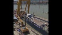 À l'aide d'une grue et de sangles, des sauveteurs ont repêché l'épave du bateau naufragé à Budapest