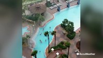Kids play on as a waterspout forms in the hotel pool