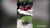 Cars make waves driving through streets covered in water