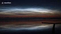 Shiny noctilucent clouds 'dance' in the skies above lake in the Netherlands