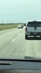 Un suspect s'évade d'une voiture de police en train de rouler !