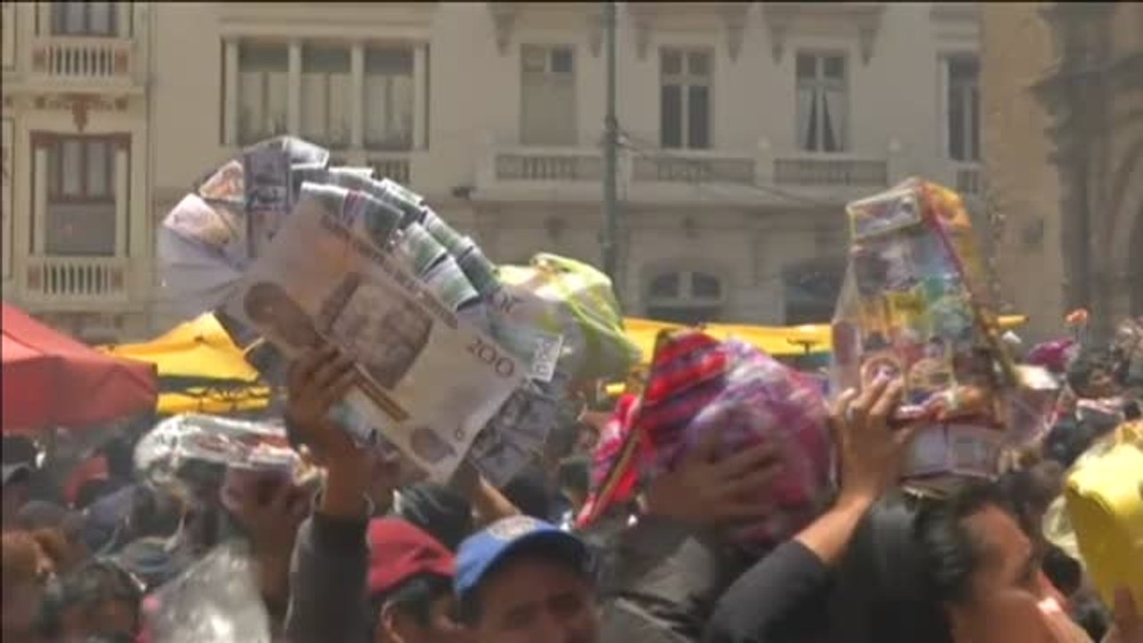 Miles de devotos en Bolivia piden al dios de la abundancia que les conceda los pequeños artículos pero en tamaño real