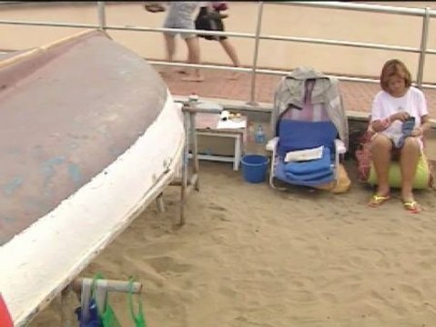 Una pareja vive bajo un barca en la playa de las Canteras en Las Palmas de Gran Canaria