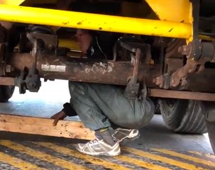 Un joven sale de los bajos de una camión en Ceuta.