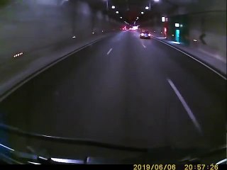 Un camion pousse une voiture dans un tunnel