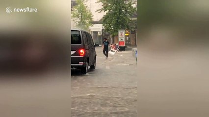 Bartenders chase after furniture being swept away by flooding in Scotland