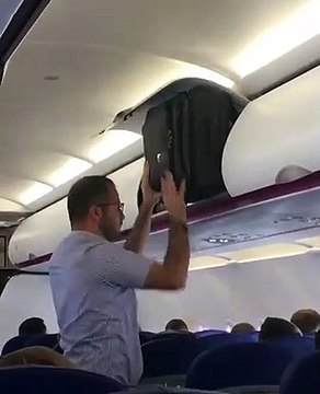 Cet homme n'arrive pas à mettre sa valise dans le coffre à bagages