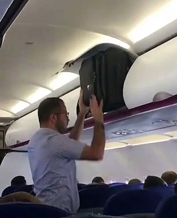 Cet homme n'arrive pas à mettre sa valise dans le coffre à bagages