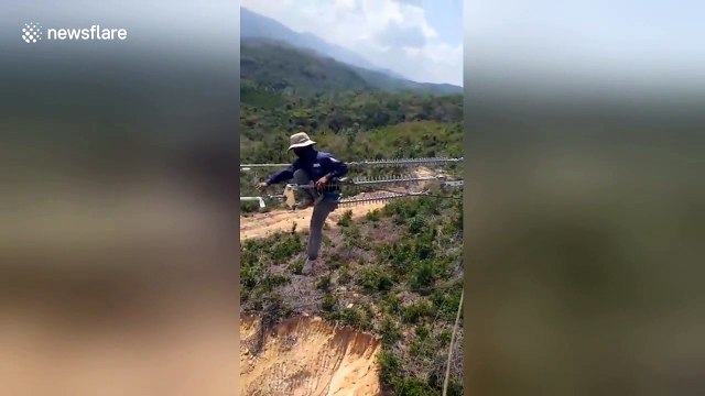 Vietnamese electrical workers do line repairs at terrifying heights