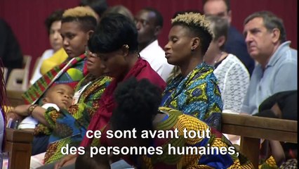 Des migrants réagissent après la messe du pape François
