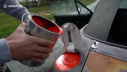 US car bursts into smoke after red paint is poured into fuel tank