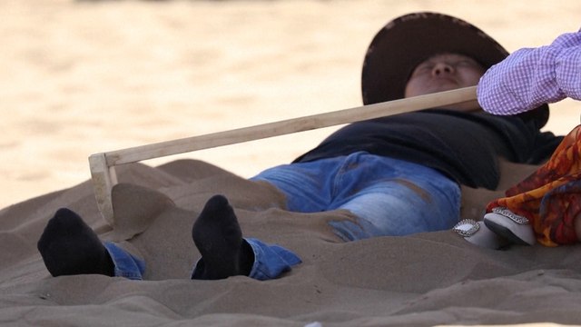 Scorching hot weather attracts tourists seeking sand therapy in northwest China