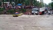 Passengers watch on as bus flips over in raging river in the Philippines