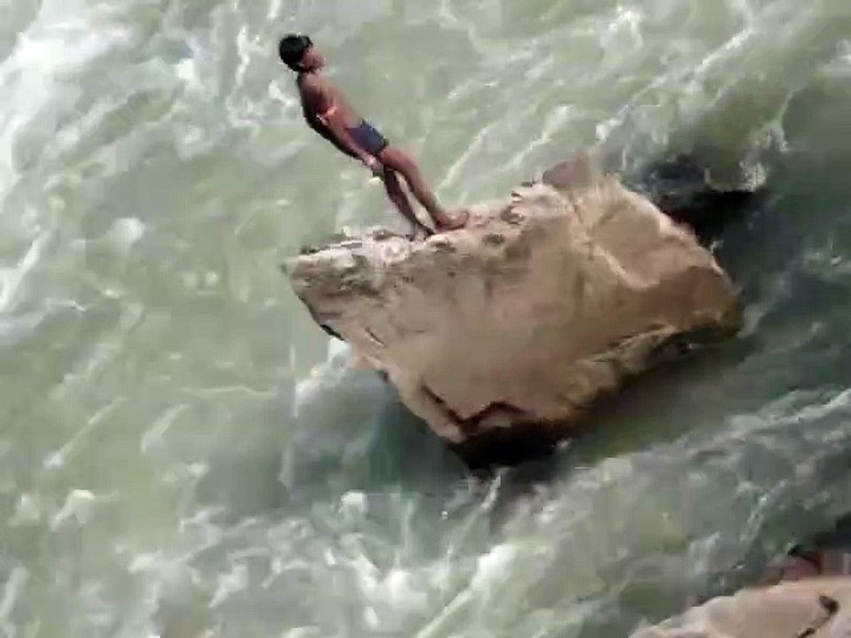 Un jeune indien plonge dans une rivière en crue...