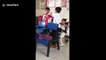 Touching moment two Filipino schoolboys help their classmate with cerebral palsy during break time