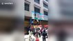 Four-year-old boy hanging from billboard falls down and caught by man in China
