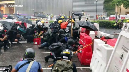 Hong Kong protesters take cover behind barricades as police fire tear gas