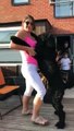 Woman dances with a dog standing on its hind legs