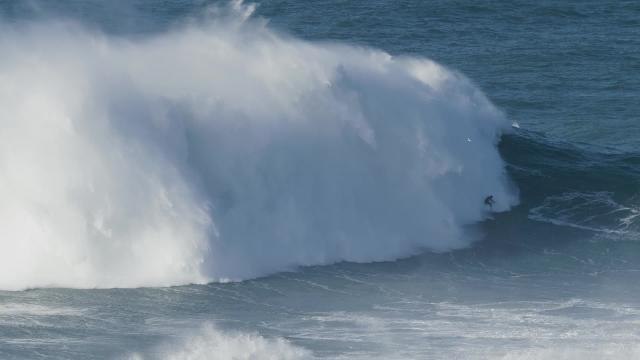 SWNS_171218_Dramatic video shows brit surfer breaking new world record for taking on the biggest ever wave