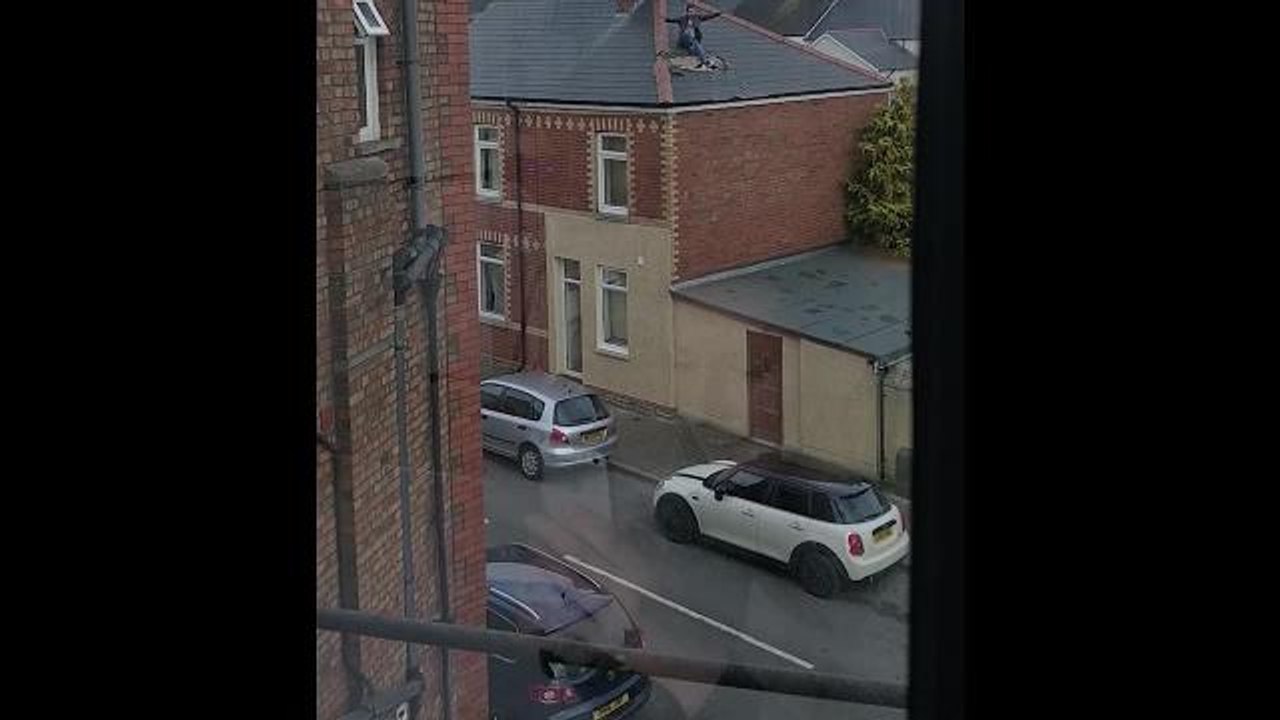 SWNS - The incredible moment a man avoids being captured by the police by bursting through his roof