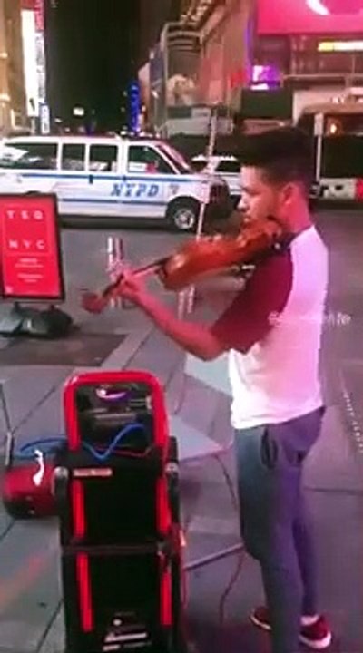 Un groupe d'amis dansent sur les rythmes d'une musique jouée par un jeune homme dans la rue