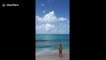 Beachgoers watch as planes fly low over Caribbean beach