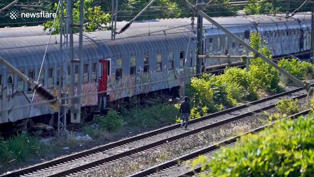 Refugees in Greece occupy train cars, creating an illegal camp alongside active train lines