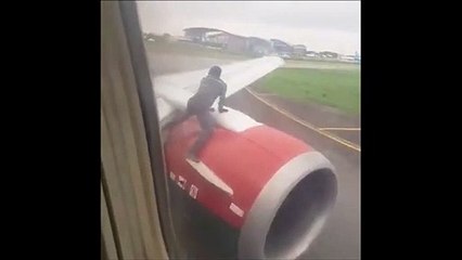 Il grimpe sur l'aile d’un avion juste avant le décollage