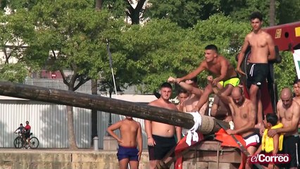 La tradicional cucaña sobre el Guadalquivir es un atractivo más de la Velá de Triana