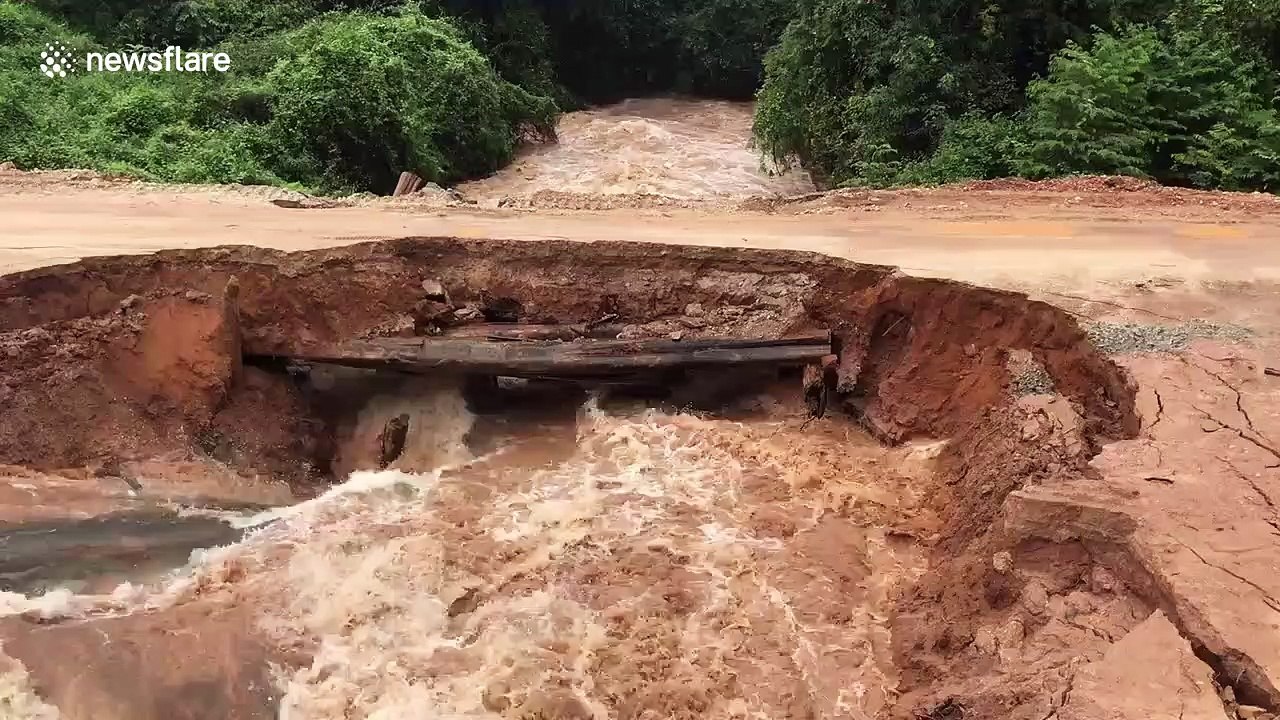 Shocking moment motorcyclists plunge into rapid floodwater after makeshift bridge collapses in Cambodia