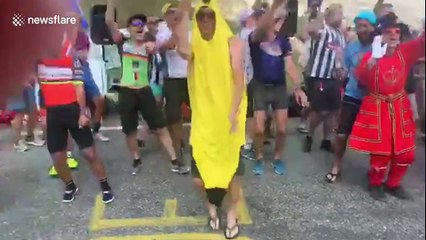 Fans dressed as British Beefeaters dance at the Tour de France